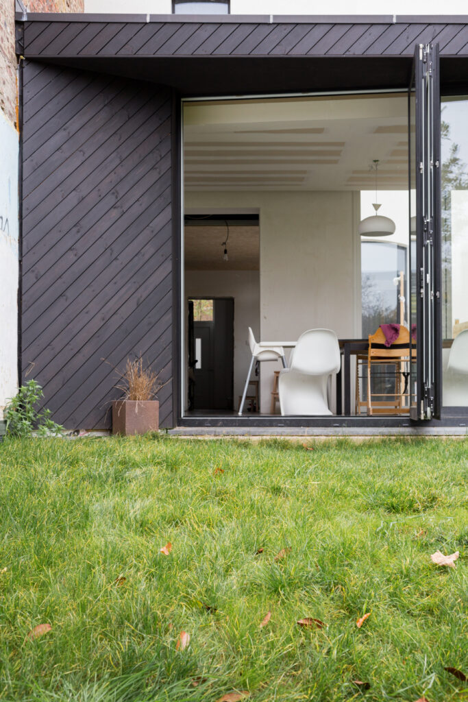 Baies accordéon ouvertes reliant la cuisine au jardin, extension à Gembloux