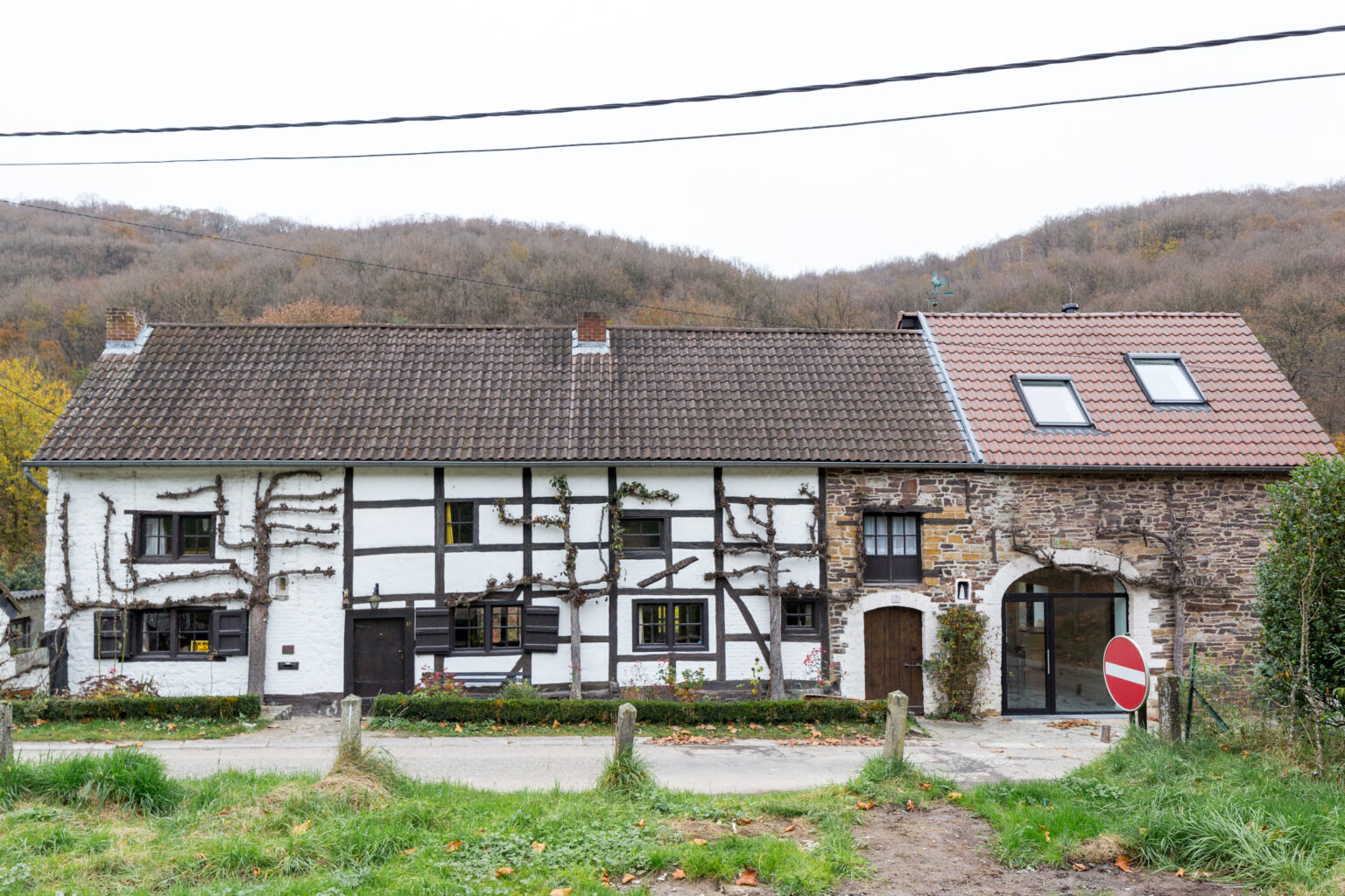 Façade à rue en colombages et pierre préservée de la grange de Lustin