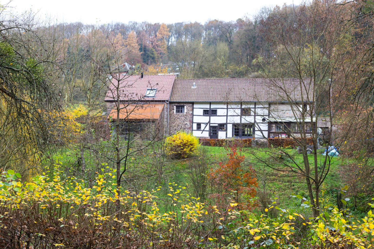 Ancienne grange de Lustin dans son paysage vallonné et boisé
