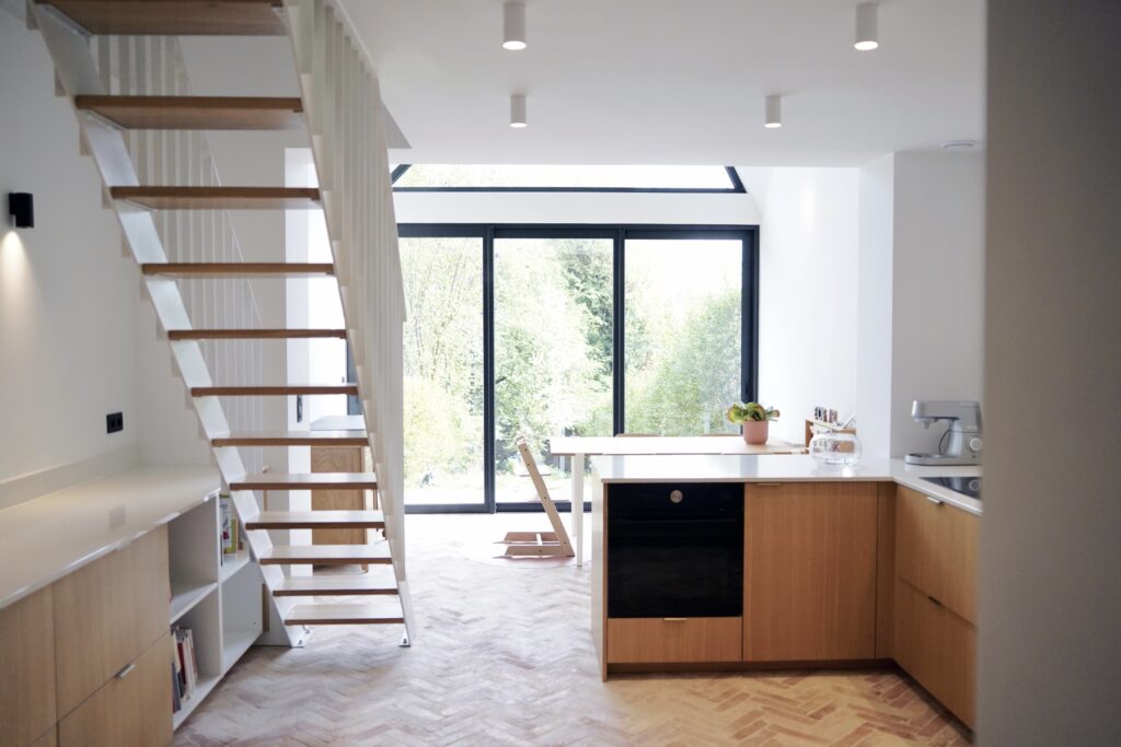 Cuisine ouverte sur l'extension vitrée et le jardin, transformation de maison à Auderghem