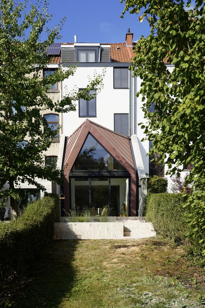 Extension contemporaine en double hauteur vue depuis le fond du jardin, maison à Auderghem