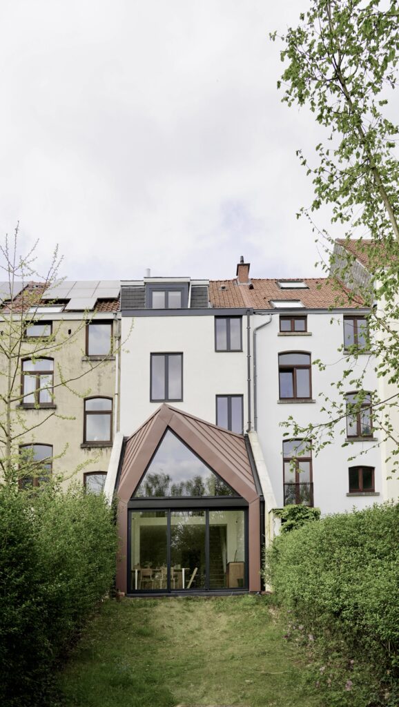 Façade arrière et extension à pignon en zinc rougeâtre vues du jardin, rue de la Vignette
