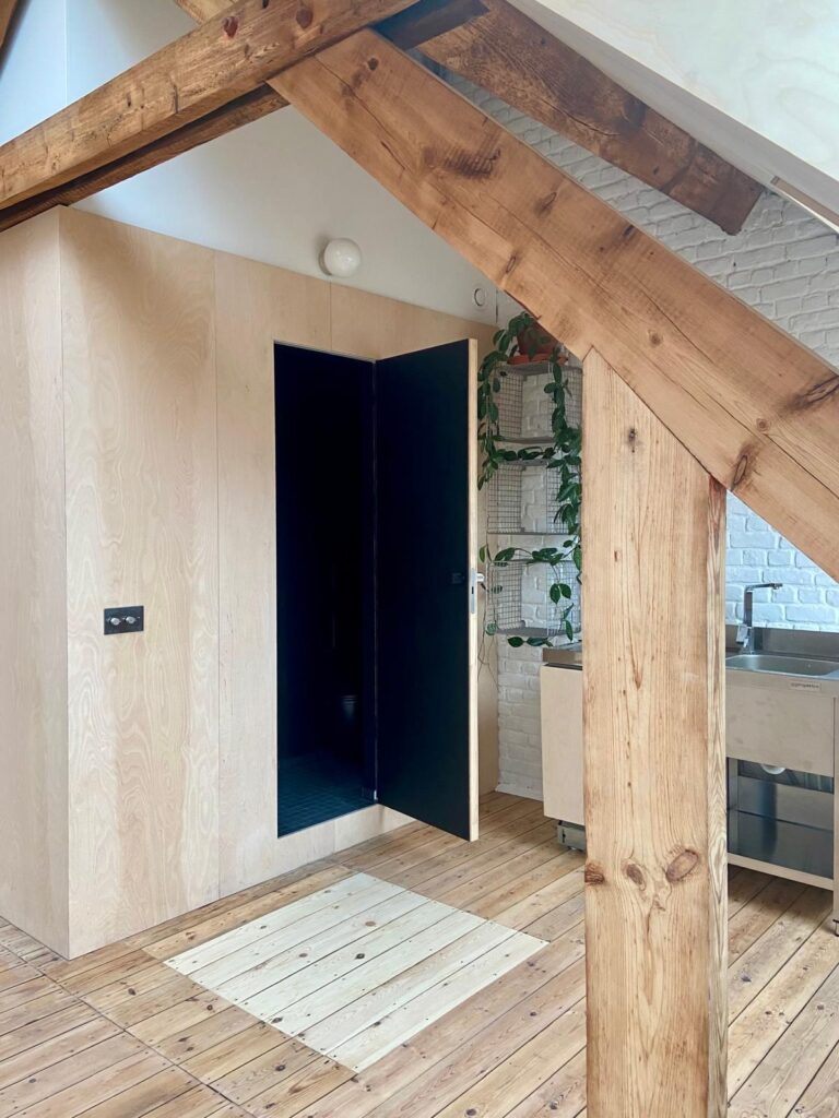 Entrée du volume central et poutres en bois apparentes, comble aménagé à Etterbeek