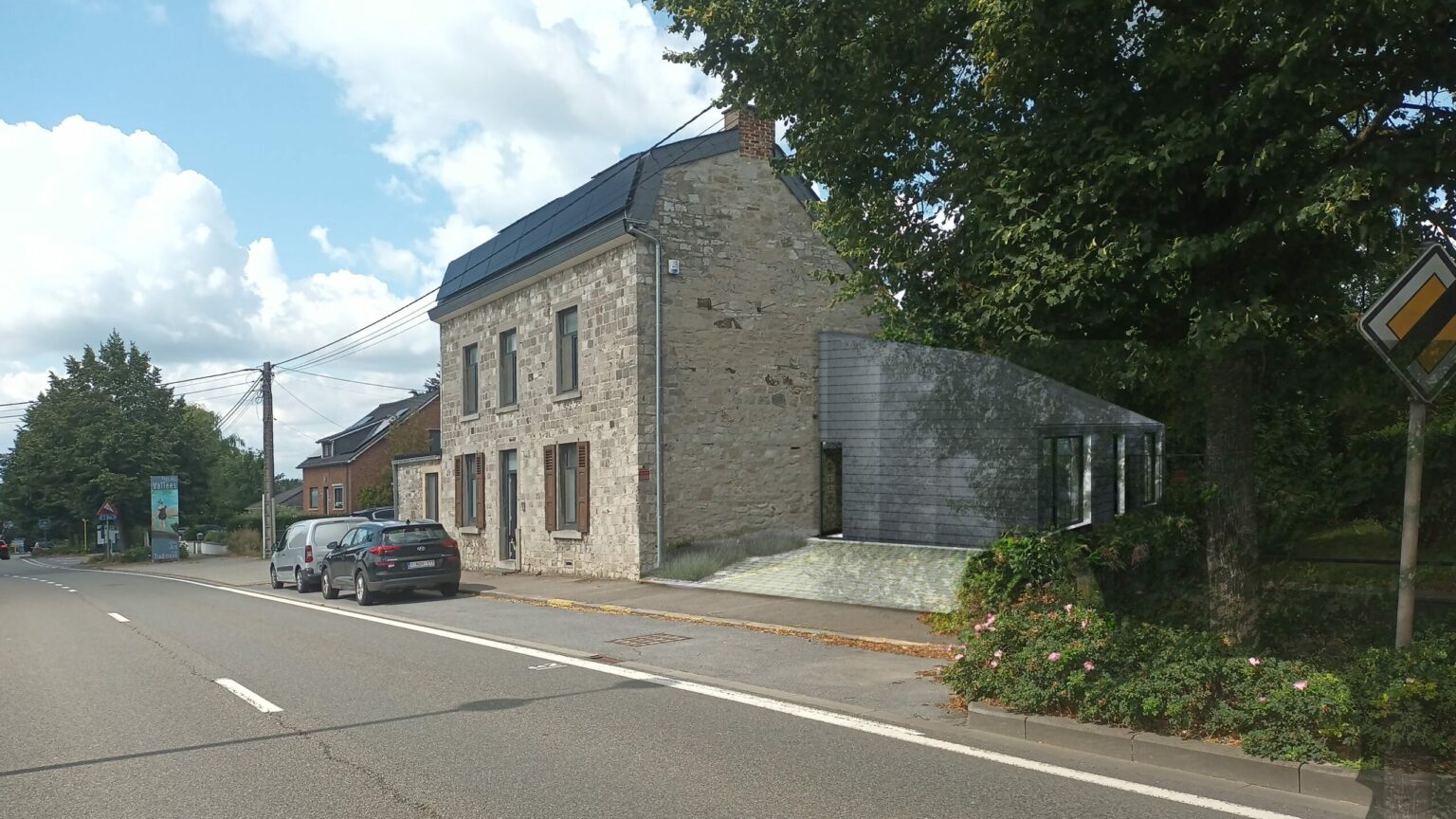 Maison en pierre en bord de route à Bouge prolongée par l'extension contemporaine en ardoise