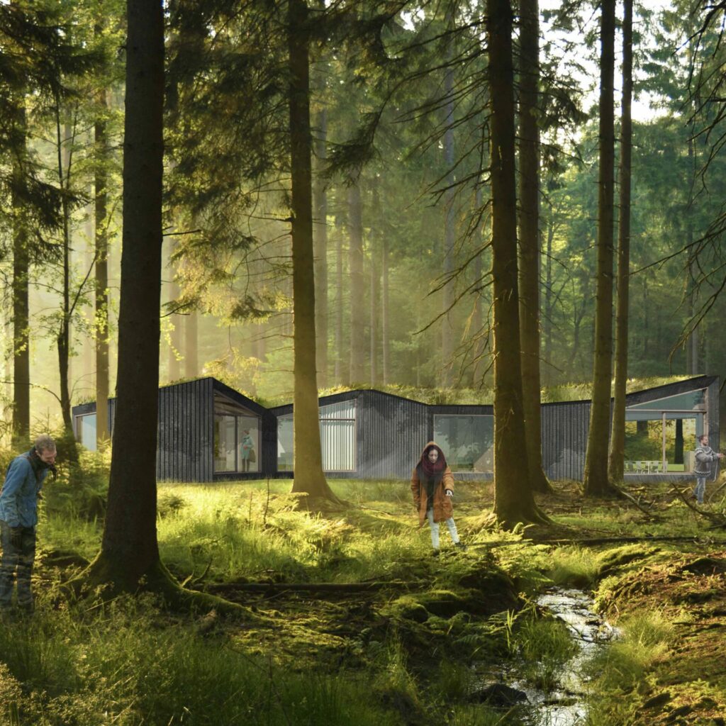 Cabanes en bois brûlé noir dispersées dans la forêt, village écologique Ekwu en Condroz