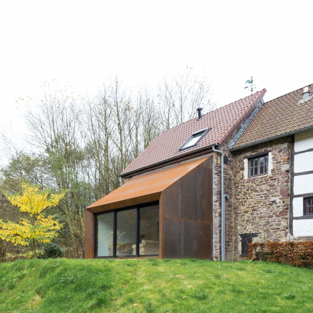 Ancienne grange à colombages de Lustin avec extension contemporaine en acier corten