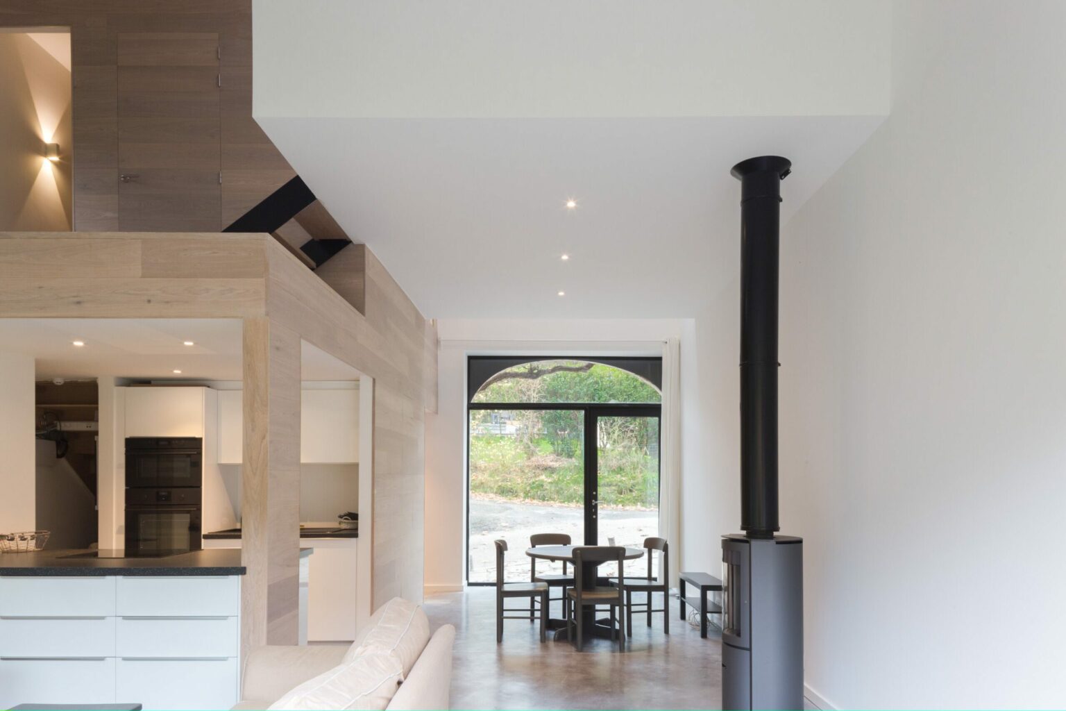 Séjour lumineux de la grange rénovée de Lustin, poêle à bois et volume central en bois clair