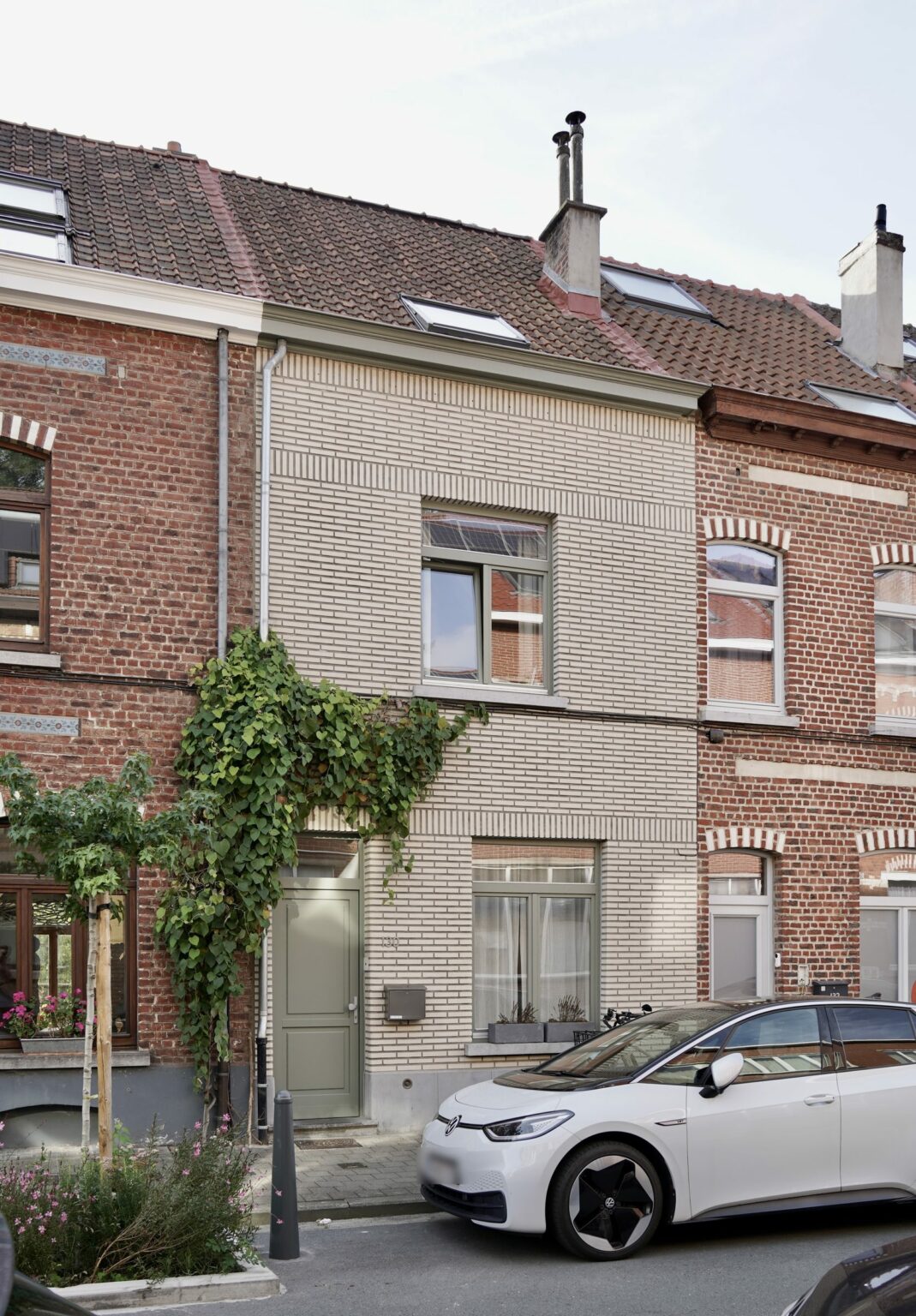 Façade rue en brique claire et porte vert sauge, maison rue de la Vignette à Auderghem