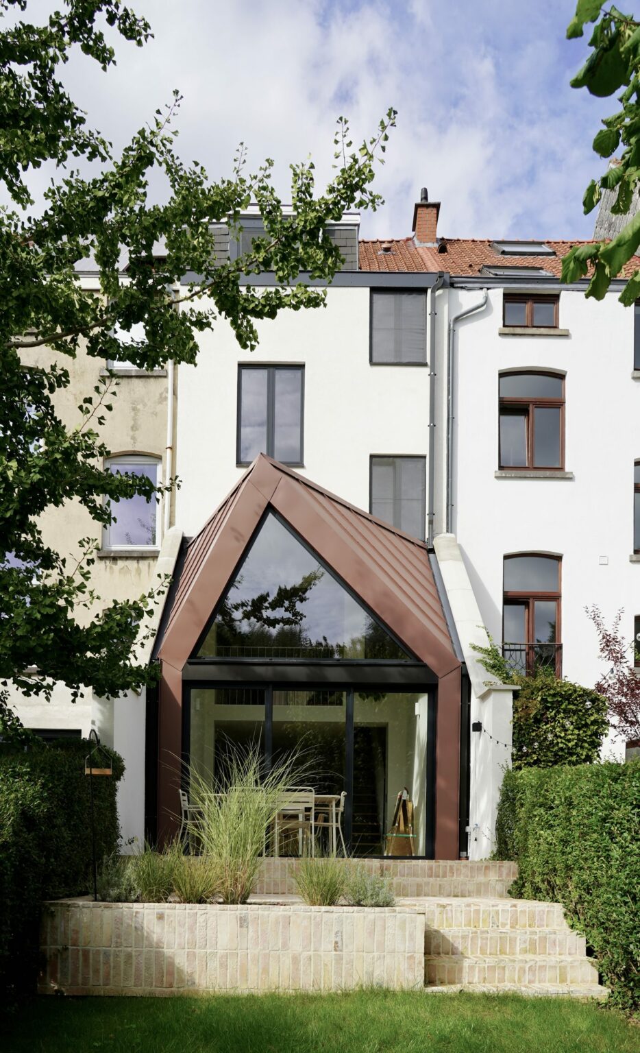 Pignon plié en zinc cuivré vu depuis la terrasse en briques, rue de la Vignette