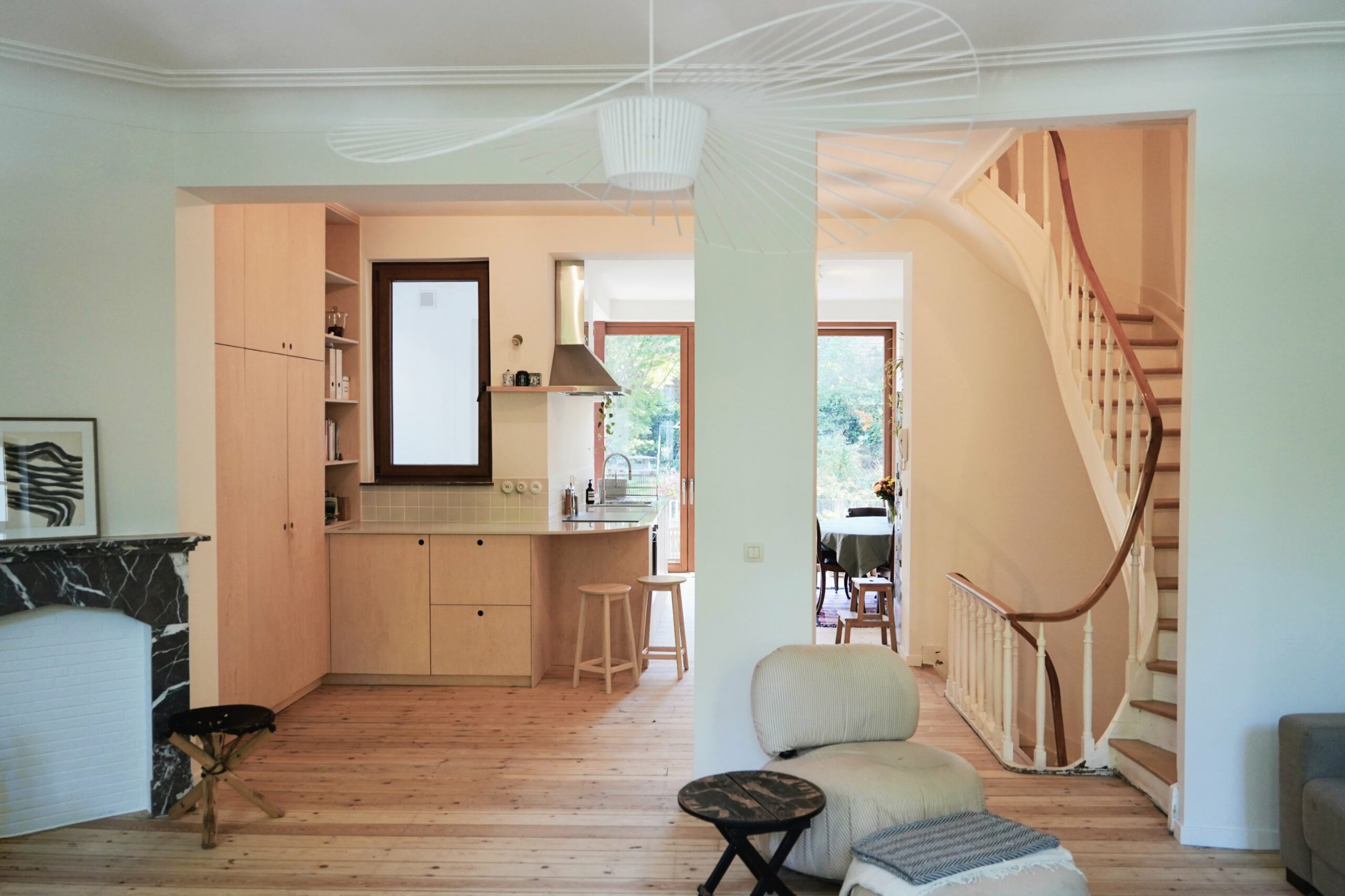 Salon avec cheminée en marbre noir ouvert en enfilade sur la cuisine et le jardin, Schaerbeek